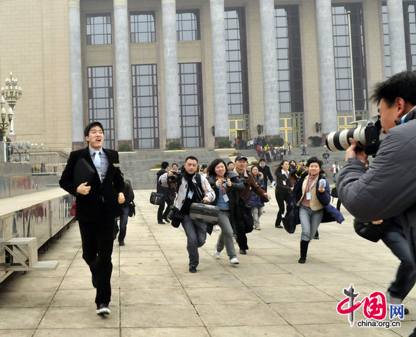 Liu Xiang, gold medalist in the man&apos;s 110-m hurdles at the Athens Olympics, finds himself in a media scrum on Wednesday as he attends the opening ceremony of the annual session of the Chinese People&apos;s Political Consultative Conference in Beijing. [CFP]