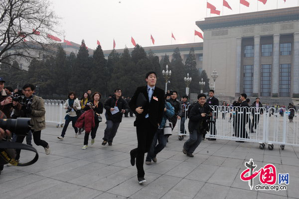 Liu Xiang, gold medalist in the man&apos;s 110-m hurdles at the Athens Olympics, finds himself in a media scrum on Wednesday as he attends the opening ceremony of the annual session of the Chinese People&apos;s Political Consultative Conference in Beijing. [CFP]