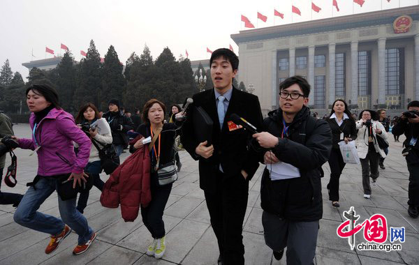 Liu Xiang, gold medalist in the man&apos;s 110-m hurdles at the Athens Olympics, finds himself in a media scrum on Wednesday as he attends the opening ceremony of the annual session of the Chinese People&apos;s Political Consultative Conference in Beijing. [CFP]