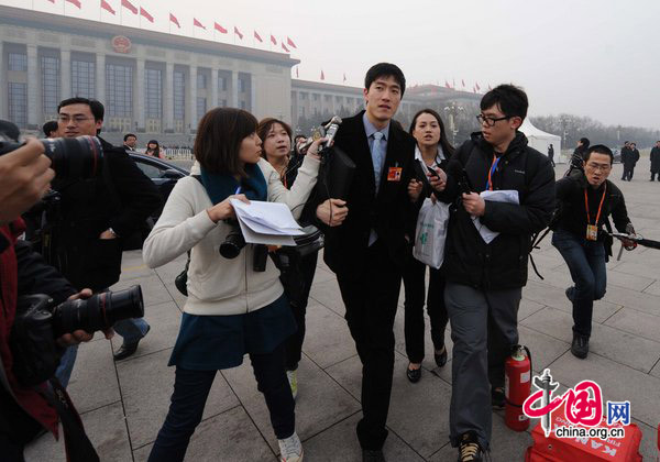 Liu Xiang, gold medalist in the man&apos;s 110-m hurdles at the Athens Olympics, finds himself in a media scrum on Wednesday as he attends the opening ceremony of the annual session of the Chinese People&apos;s Political Consultative Conference in Beijing. [CFP]