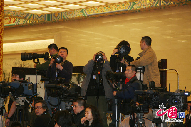 Photographers at work during a press conference of the 3rd session of the 11th National People's Congress (NPC) in the Great Hall of the People in Beijing, March 4, 2010. [Li Shen/China.org.cn]