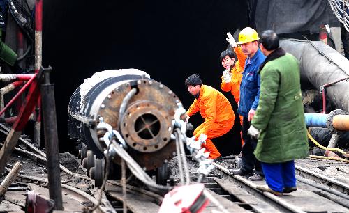 Rescue workers transport a pump in to a flooded pit of Luotuoshan Coal Mine in Wuhai City, north China's Inner Mongolia Autonomous Region, March 3, 2010. [Ren Junchuan/Xinhua]