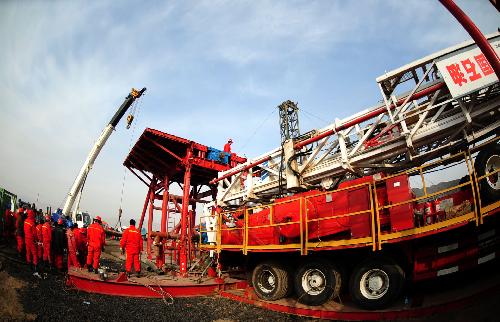 Rescue workers install a drill at the Luotuoshan Coal Mine in Wuhai City, north China's Inner Mongolia Autonomous Region, March 3, 2010. Rescuers are still draining a flooded coal mine in north China's Inner Mongolia Autonomous Region Wednesday, hoping to rescue 31 trapped miners in the pit who have been there for more than 50 hours. [Ren Junchuan/Xinhua]