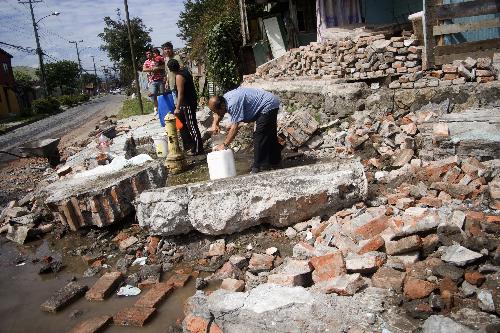 People look for clean water in the quake-devastated Concepcion, Chile, March 3, 2010. The number of deaths from the 8.8-magnitude earthquake in Chile and ensuing Tsunami could exceed 800, President Michelle Bachelet said on Wednesday. [Victor Rojas/Xinhua]