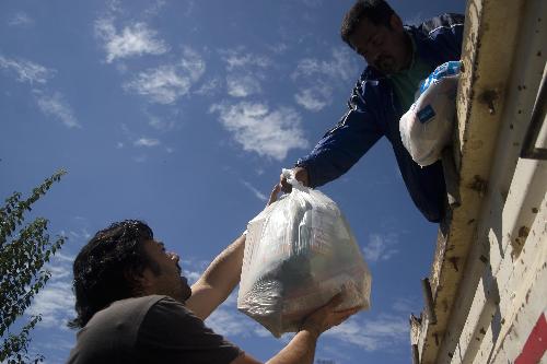 A worker delivers humanitarian materials in the quake-devastated Concepcion, Chile, March 3, 2010. The number of deaths from the 8.8-magnitude earthquake in Chile and ensuing Tsunami could exceed 800, President Michelle Bachelet said on Wednesday.[Victor Rojas/Xinhua]