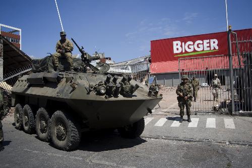 Chilian soldiers stand guard in a supermarket in the quake-devastated Concepcion, Chile, March 3, 2010. The number of deaths from the 8.8-magnitude earthquake in Chile and ensuing Tsunami could exceed 800, President Michelle Bachelet said on Wednesday. [Victor Rojas/Xinhua]
