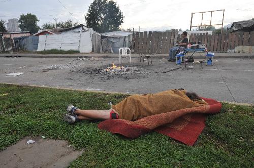 A homeless man sleeps in the open air in the suburb of quake-devastated Concepcion, Chile, March 3, 2010. The number of deaths from the 8.8-magnitude earthquake in Chile and ensuing Tsunami could exceed 800, President Michelle Bachelet said on Wednesday.[Song Weiwei/Xinhua]