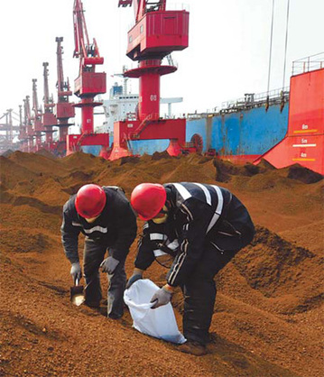 Local government officials take samples of imported iron ore for inspection at Rizhao Port in Shandong province. [Chen weifeng / China Daily]