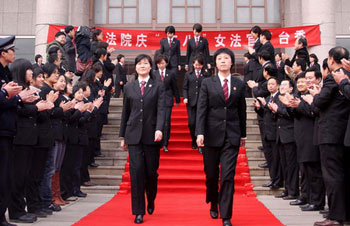 Women judges in uniform walk on the red carpet to celebrate their upcoming festival in Jinan, capital city of east China's Shandong Province, March 4, 2010. [Photo: Xinhua]