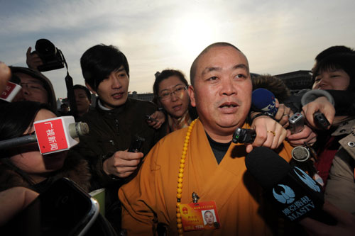 Shi Yongxin, deputy to the Third Session of the 11th National People's Congress (NPC) and also abbot of Shaolin temple, is interviewed prior the opening meeting of the Third Session of the 11th NPC outside the Great Hall of the People in Beijing, capital of China, March 5, 2010. The Third Session of the 11th NPC opened on Friday. [Jin Liangkuai/Xinhua]