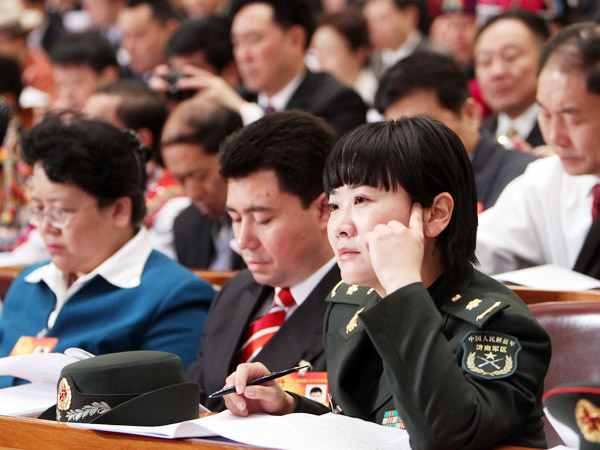 A deputy (front) to the Third Session of the 11th National People's Congress (NPC) listens carefully to Premier Wen's government work report in the Great Hall of the People in Beijing, capital of China, March 5, 2010. The Third Session of the 11th NPC opened on Friday. [China.org.cn]