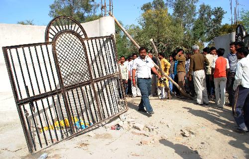 People gather near the site after a stampede broke out at a temple in Kunda, some 180 kilometers southeast of Lucknow, capital of Indian northern state of Uttar Pradesh, on March 4, 2010. At least 65 people, including women and children, were killed and some 400 others injured in a stampede at a temple where thousands of devotees gathered for a religious ritual. [Stringer/Xinhua] 