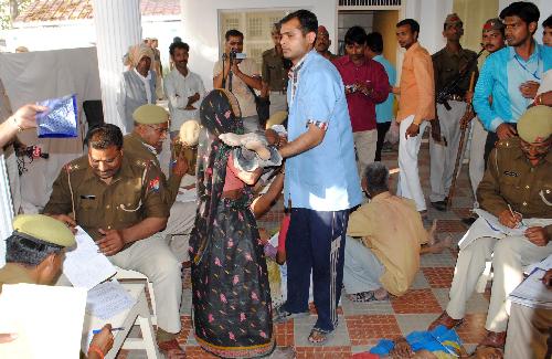 Police count the number of victims who died in a stampede at a temple in Kunda, some 180 kilometers southeast of Lucknow, capital of Indian northern state of Uttar Pradesh, on March 4, 2010. At least 65 people, including women and children, were killed and some 400 others injured in a stampede at a temple where thousands of devotees gathered for a religious ritual. [Stringer/Xinhua] 