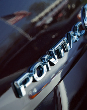 An American flag is reflected on the back of a Pontiac G8 sedan at a General Motors auto dealership in Nanuet, New York, April 27, 2009. [Xinhua]