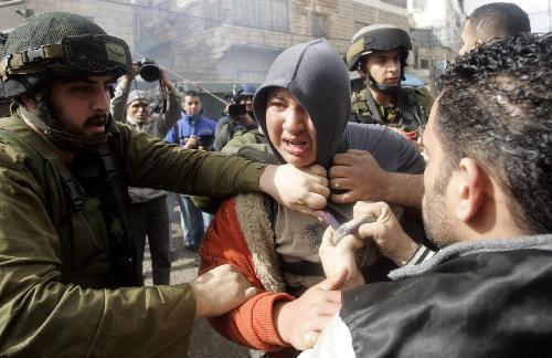 Israeli soldiers arrest a Palestinian youth during clashes with Palestinian protestors in the West Bank city of Hebron, on February 26, 2010. [Xinhua photo]