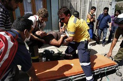 A woman, victim of a panic attack after a tsunami alert, is loaded on a stretcher in Constitucion, Chile, Wednesday, March 3, 2010.