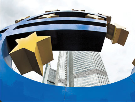 The euro sculpture is seen in front of the European Central Bank in Frankfurt, Germany. The ECB yesterday left its benchmark interest rate unchanged at 1 percent as markets wait to see if it will scale back special lending to banks introduced during the financial crisis. [Shanghai Daily]