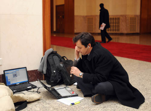 A journalist with BBC works during the opening meeting of the Third Session of the 11th National People's Congress (NPC) at the Great Hall of the People in Beijing, capital of China, March 5, 2010. [Jin Liangkuai/Xinhua]