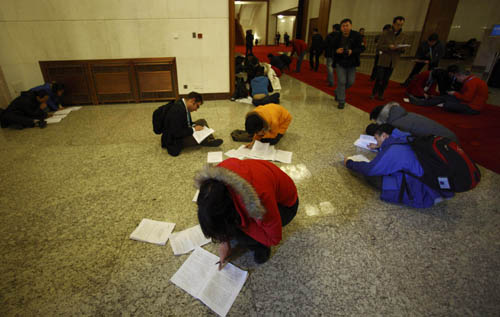 Journalists work prior to the opening meeting of the Third Session of the 11th National People's Congress (NPC) at the Great Hall of the People in Beijing, capital of China, March 5, 2010. [Fei Maohua/Xinhua]