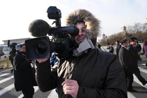 A foreign journalist works prior to the opening meeting of the Third Session of the 11th National People's Congress (NPC) at the Tiananmen Square in Beijing, capital of China, March 5, 2010. [Li Ziheng/Xinhua]