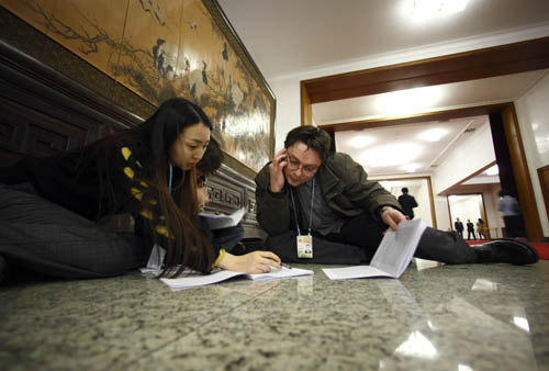 Journalists work prior to the opening meeting of the Third Session of the 11th National People's Congress (NPC) at the Great Hall of the People in Beijing, capital of China, March 5, 2010. [Fei Maohua/Xinhua]