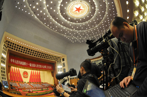 Journalists work during the opening meeting of the Third Session of the 11th National People's Congress (NPC) at the Great Hall of the People in Beijing, capital of China, March 5, 2010. [Yang Zongyou/Xinhua]