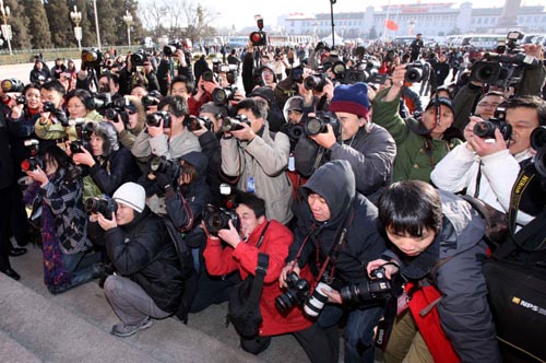 Photographers work prior to the opening meeting of the Third Session of the 11th National People's Congress (NPC) outside the Great Hall of the People in Beijing, capital of China, March 5, 2010. [Chen Jianli/Xinhua]