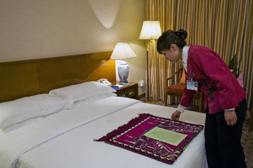 An attendant settles prayer rug for Muslim members of the 11th National Committee of the Chinese People's Political Consultative Conference (CPPCC) at Beijing Friendship Hotel in Beijing, China, March 1, 2010. Convenient services are provided for CPPCC members with special needs during the Third Session of the 11th CPPCC National Committee in Beijing. (Xinhua/Jin Liangkuai) 