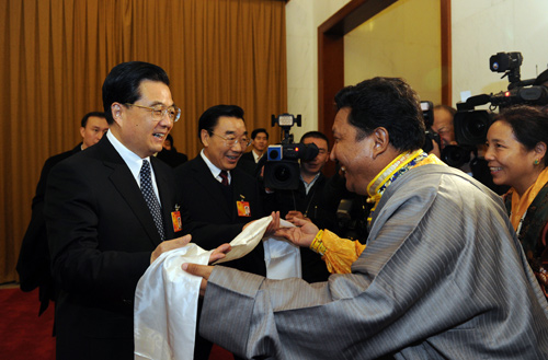 Chinese President Hu Jintao (L, front) receives Hada from a Tibetan deputy when joining a panel discussion with deputies to the Third Session of the 11th National People&apos;s Congress (NPC) from west China&apos;s Tibet Autonomous Region, in Beijing, capital of China, March 6, 2010. [Rao Aimin/Xinhua]