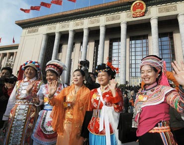 Deputies of ethnic minorities pose before the Great Hall of the People where the opening meeting of the Third Session of the 11th National People's Congress was held. [Fan Wenjun / womenofchina.cn]