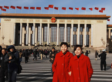 Two guiding women pose before the Great Hall of the People where the opening meeting of the Third Session of the 11th National People's Congress was held. [Fan Wenjun / womenofchina.cn]