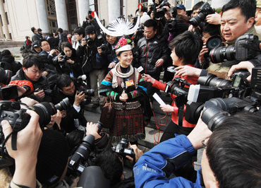 A deputy of Miao ethnicity is surrounded by the journalists after the opening of the Third Session of the 11th National People's Congress (NPC), March 5th. [Fan Wenjun / womenofchina.cn]