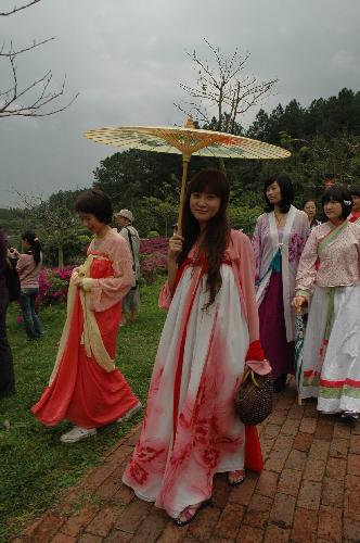 Young girls in traditional Chinese enjoy a moment as they tour in a forest park in Fogang county, south China's Guangdong Province, March 7, 2010. The women who wear the traditional Chinese clothes are granted free entrance admission on the occasion of the International Women's Day on March. 8, 2010. [Xinhua]