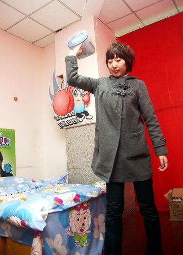 A woman smashes things in an area decorated like a bedroom at a mall in Shenyang, capital of northeast China's Liaoning province, March 5, 2010, to celebrate the International Women's Day, which falls on March 8. [Photo/CFP] 