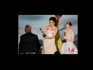 Musician T Bone Burnett (L) walks onstage to accept Best Song award for 'The Weary Kind' (from 'Crazy Heart') from presenters Miley Cyrus and Amanda Seyfried during the 82nd Annual Academy Awards held at Kodak Theatre on March 7, 2010 in Hollywood, California. [CFP]