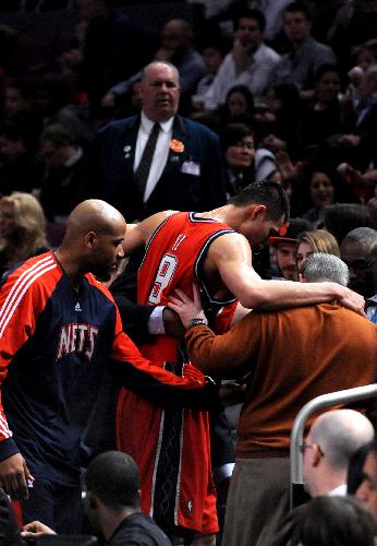 Yi Jianlian (C) of New Jersey Nets leaves the court because of injury during the NBA game against New York Knicks in New York, the United State, Mar. 6, 2010. Nets won 113-93. (Xinhua/Shen Hong) 