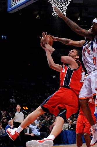 Brook Lopez (L) of New Jersey Nets is tackled during the NBA game against New York Knicks in New York, the United State, Mar. 6, 2010. Nets won 113-93. (Xinhua/Shen Hong) 