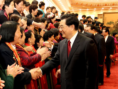 Chinese President Hu Jintao, who is also General Secretary of the Central Committee of the Communist Party of China (CPC) and Chairman of the Central Military Commission, shakes hands with female representatives before a meeting which marks the 100th anniversary of the International Women's Day at the Great Hall of the People in Beijing, China, March 7, 2010. [Xinhua]