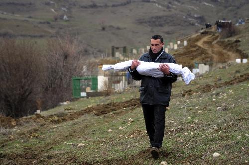 A man carries the body of a girl who was killed during an earthquake in Okcular Village, Elazig province, March 8, 2010. A powerful pre-dawn earthquake buried sleeping villagers in remote eastern Turkey Monday, claiming at least 51 lives and leaving dozens injured, officials said.[Xinhua]