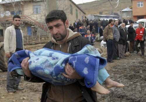 A man carries the body of a girl who was killed during an earthquake in Okcular Village, Elazig province, March 8, 2010.[Xinhua]