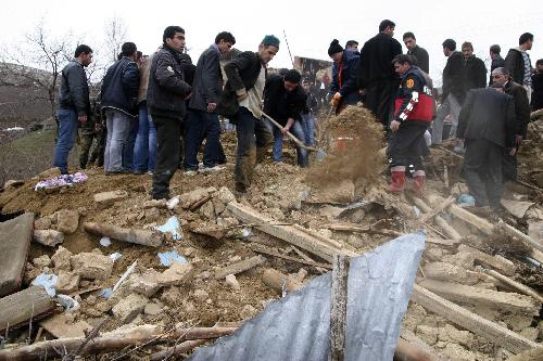 Rescue workers and people remove rubble from a destroyed house in Okcular village in the eastern province of Elazig, Turkey, Monday, March 8, 2010.[Xinhua]