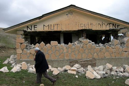 A man walks past a damaged house after the earthquake in Turkish eastern province of Elazig, on March 8, 2010.[Xinhua] 