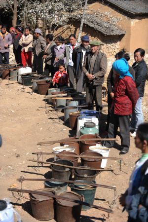  A Villagers queue for water in Dongshan Town of Xuanwei City, southwest China's Yunnan Province, on March 5, 2010. Drought had affected 61.31 million Mu (4.09 million hectares) of farmland in southwestern China as of March 5, according to the latest figure from the Ministry of Agriculture (MOA).[Xinhua]
