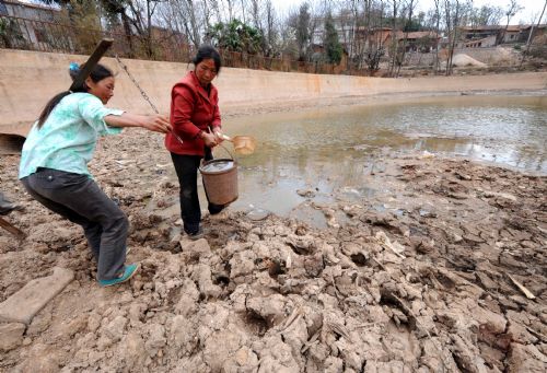 Villagers fetch water from a almost-dried pond in Luoshui Town of Xuanwei City, southwest China's Yunnan Province, on March 4, 2010. Drought had affected 61.31 million Mu (4.09 million hectares) of farmland in southwestern China as of March 5, according to the latest figure from the Ministry of Agriculture (MOA).[Xinhua]