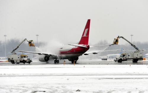 Deicing trucks work for a flight at the Beijing Capital International Airport in Beijing, capital of China, March 8, 2010. The urban area of Beijing had received 4.2 millimeters of snow Monday. By Monday morning, 49 flights had been canceled and 28 others delayed because of the snow. [Xinhua]