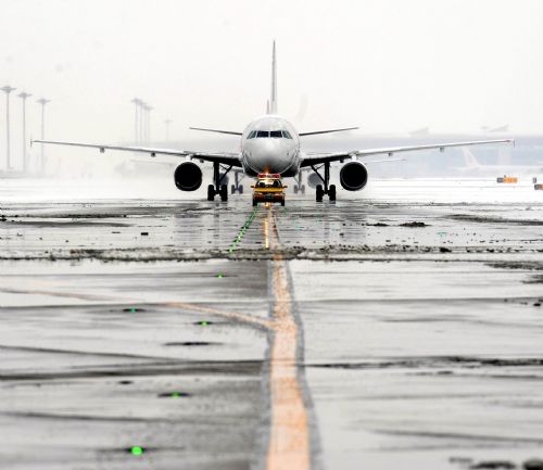 A flight waits for takeoff at the Beijing Capital International Airport in Beijing, capital of China, March 8, 2010. The urban area of Beijing had received 4.2 millimeters of snow Monday. By Monday morning, 49 flights had been canceled and 28 others delayed because of the snow. [Xinhua]