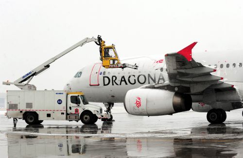 A deicing truck works for a flight at the Beijing Capital International Airport in Beijing, capital of China, March 8, 2010. The urban area of Beijing had received 4.2 millimeters of snow Monday. By Monday morning, 49 flights had been canceled and 28 others delayed because of the snow. [Xinhua]