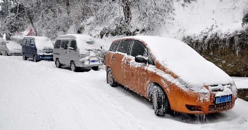 Snow-coated cars are seen on the Lushan Mountain, a famous tourist destination in east China's Jiangxi Province. Heavy snowfall hit the Lushan Mountain area on Monday and Tuesday. [Xinhua] 