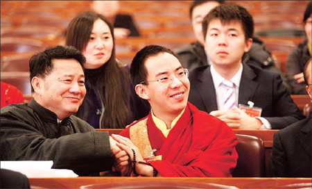 The 11th Panchen Lama, Bainqen Erdini Qoigyijabu (center), talks with members of the third session of the 11th CPPCC National Committee in Beijing on Wednesday. [Yang Shizhong/China Daily]