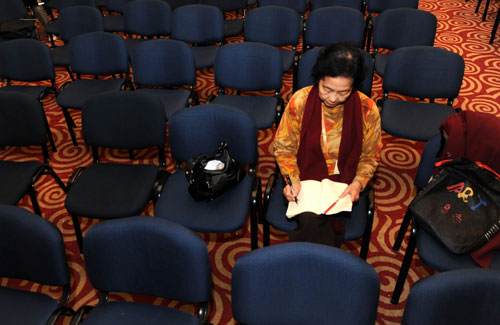 Qu Yueying, chief editor of Hong Kong View magazine, works after a press conference held at the press center of the Third Sessions of the 11th National People’s Congress and the 11th National Committee of the Chinese People's Political Consultative Conference in Beijing, capital of China, March 11, 2010. (Xinhua/Li Ziheng)